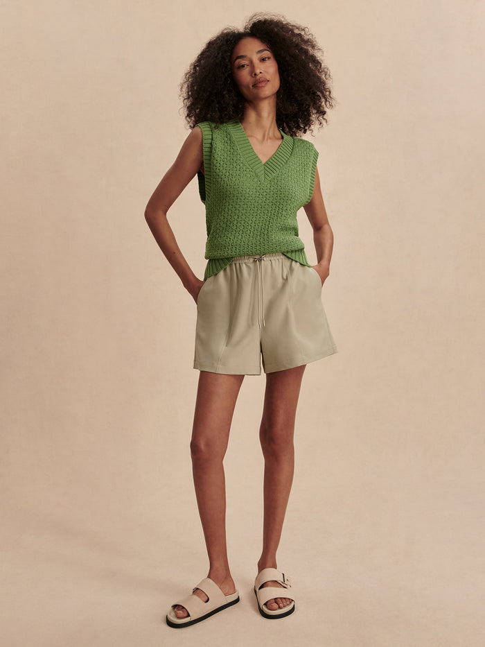 English Ivy|Front view of the Antonella Knit Vest in English Ivy, a green knit sleeveless layer worn by a model.