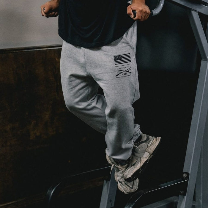 Person wearing gray sweatpants with a logo, stepping onto a vehicle.