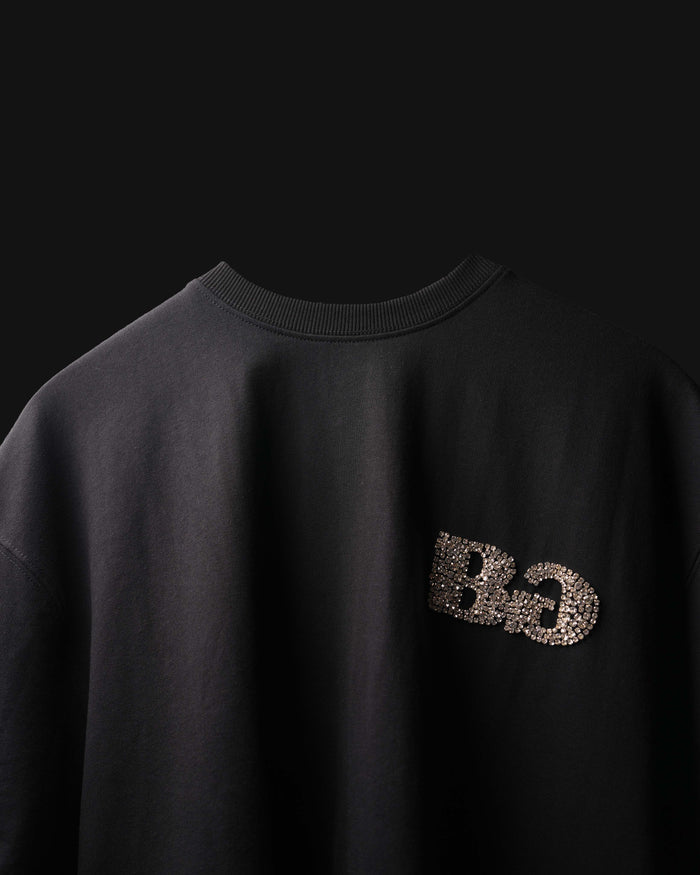 Black sweatshirt with 'DG' logo on the chest against a black background