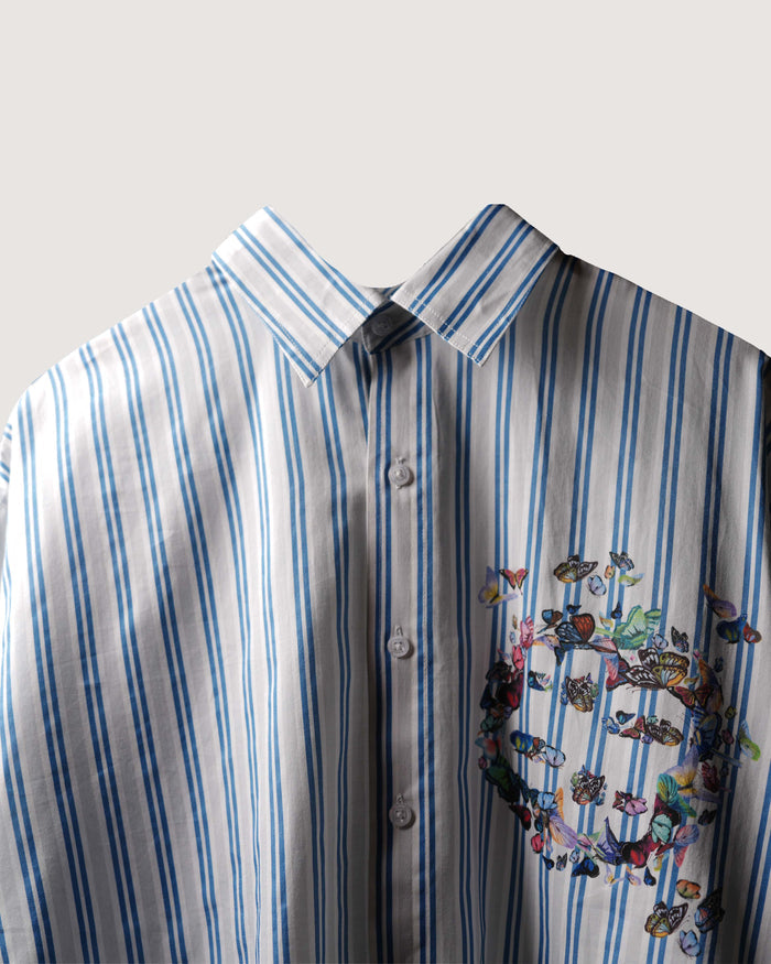 Striped shirt with a colorful butterfly design on a light gray background