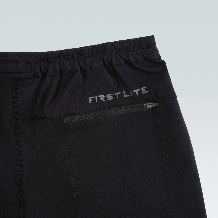 Black pants with 'First Lite' branding on a light gray background