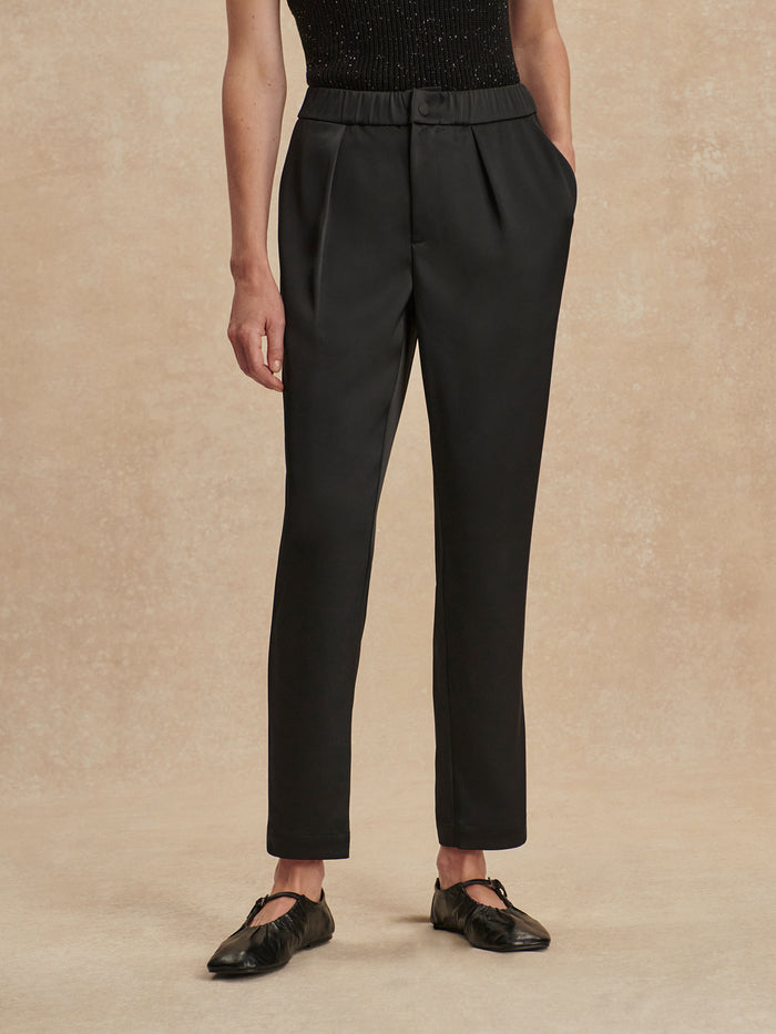 Black|Hanover Tapered Leg Pant 27 in black satin with front pleats, pockets, and elasticated waistband; drape and sheen.