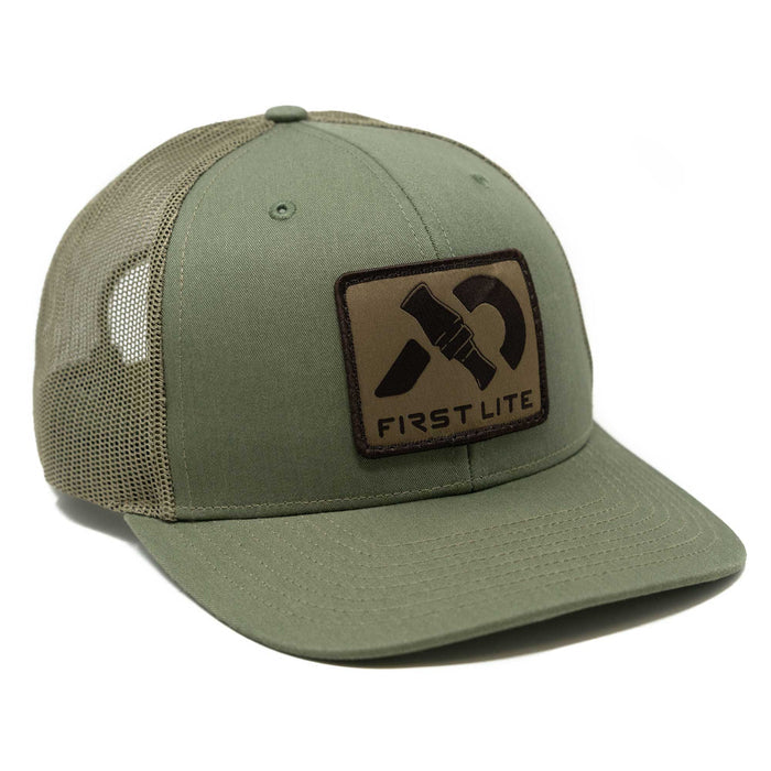 Olive green trucker hat featuring a dark brown rectangular patch on the front with a black stylized duck call graphic and "FIRST LITE" text.