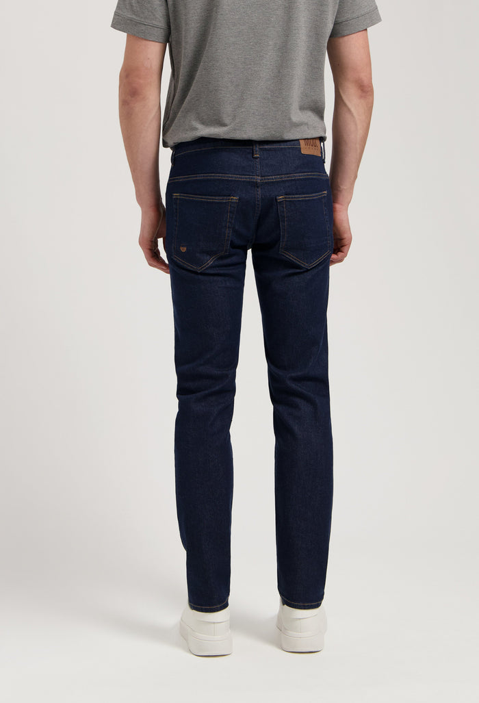 Sustainable MUD Jeans in dark denim paired with a cozy gray sweater, showcasing ethical fashion for modern style.