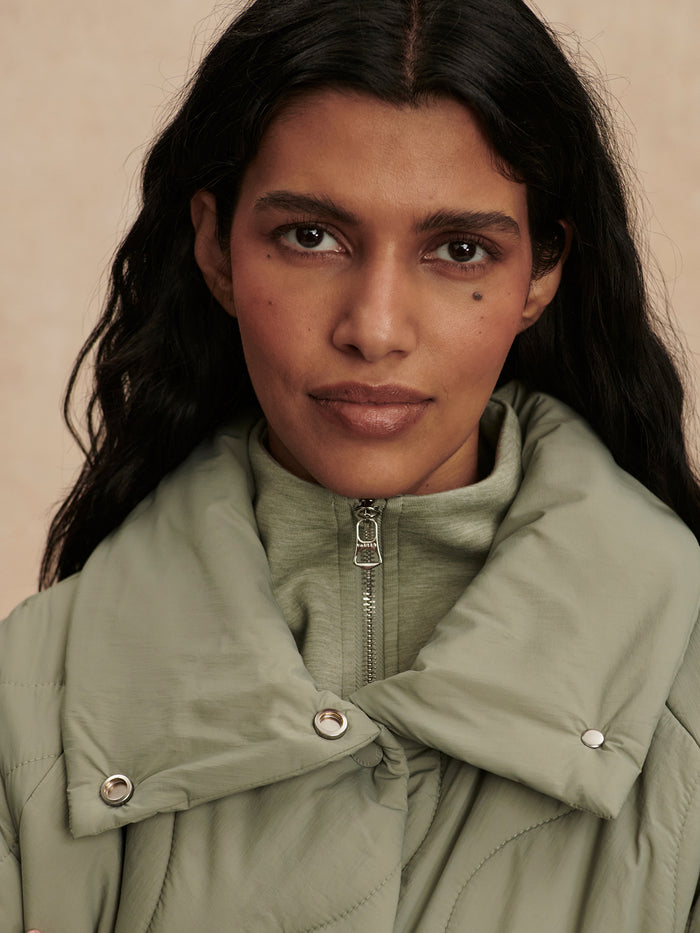 Shadow|Front view of the Varley Fabia Quilted Jacket in Shadow, dark gray quilted shell with stand collar and zip fastening.