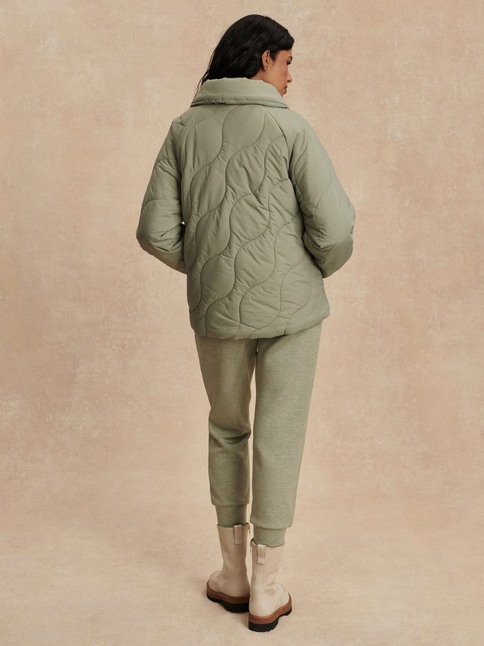 Shadow|Fabia Quilted Jacket Shadow by Varley, front view in dark grey quilted fabric with stand-up collar and zip closure.