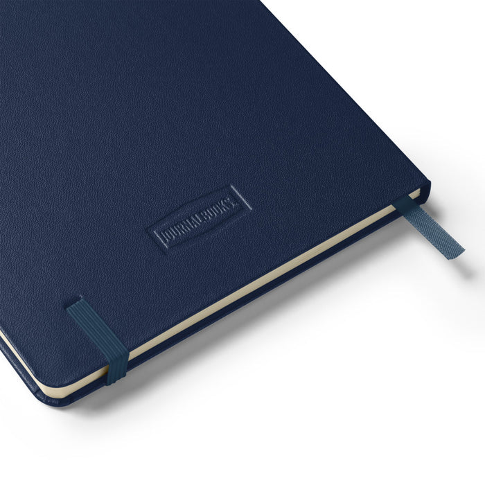 Interior view of the notebook open to lined cream-colored pages with ribbon marker