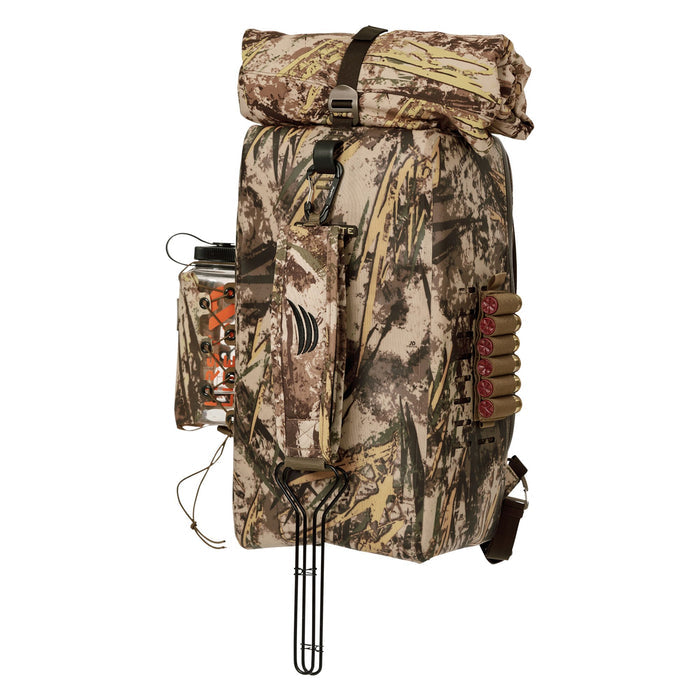 A camouflage roll-top hunting backpack with a water bottle, side shotgun shell holder with six red shells, and a metal bottom handle.