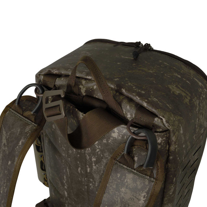 A dark digital camouflage backpack featuring shoulder straps with D-rings and a tan buckle, a zippered top, and laser-cut side vents.
