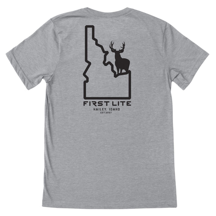 Light gray t-shirt with a black graphic on the back showing an Idaho state outline with a deer silhouette inside and text "FIRST LITE HAILEY, IDAHO EST.2007"