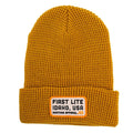 Camel ribbed knit beanie with a folded cuff and a beige square patch featuring the text "FIRST LITE IDAHO, USA Hunting Apparel"