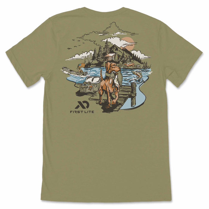 Olive green t-shirt with a back graphic depicting a retriever dog holding a fish on a dock in an outdoor lake and mountain scene, with a FIRST LITE logo.