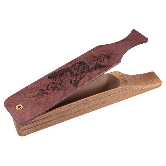 Two-toned wooden box turkey call with a reddish-brown lid engraved with a skull, feathers, and "MEATEATER PHELPS" text, slightly open to reveal the lighter wood base.