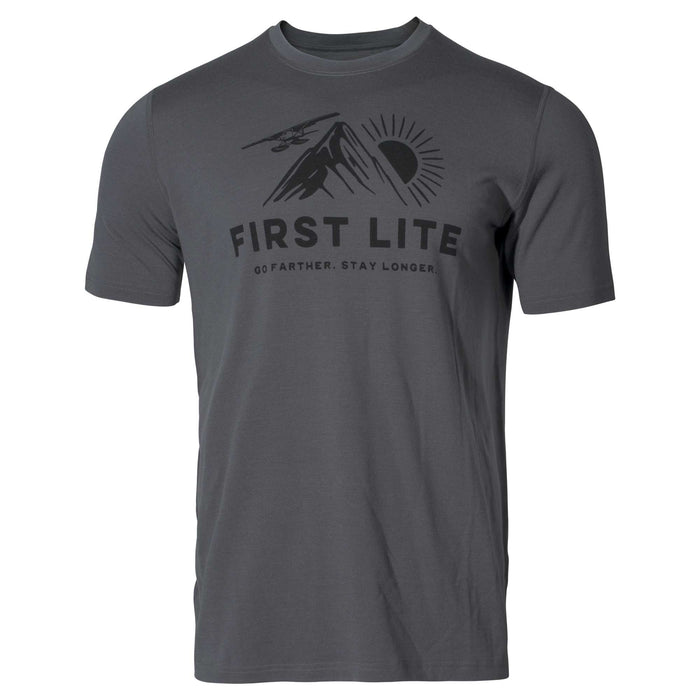 Charcoal grey t-shirt featuring a black graphic of a mountain, sun, airplane, and 'FIRST LITE GO FARTHER. STAY LONGER.' text.