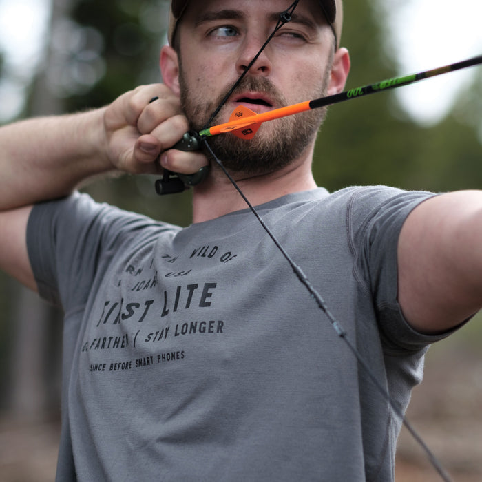 Grey heathered short-sleeved t-shirt with black graphic text on the chest, worn by a man aiming a bow.