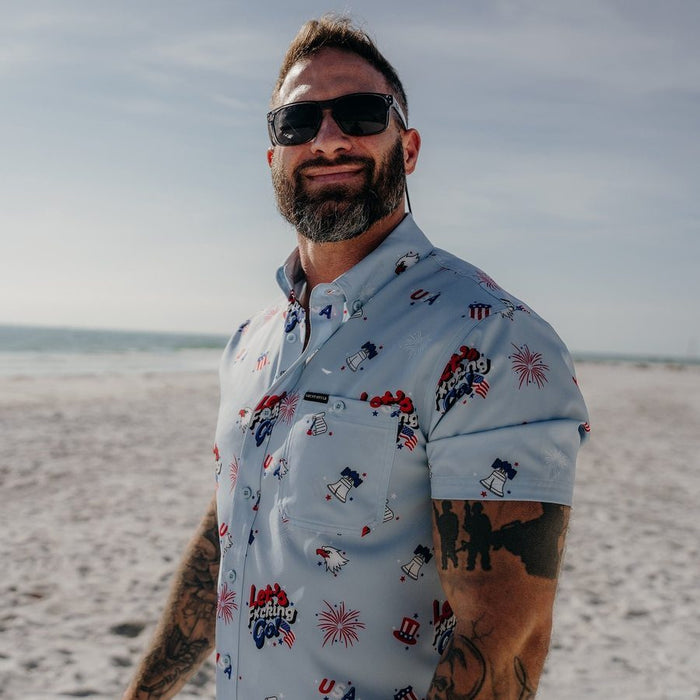 Man wearing sunglasses and a patterned shirt on a beach