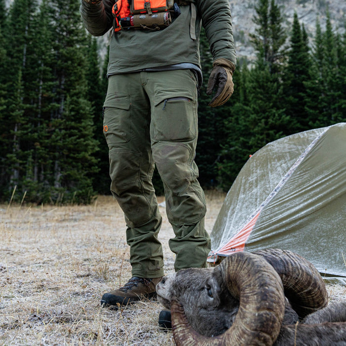 Olive green outdoor pants featuring reinforced knees, cargo pockets, and a zippered leg pocket.