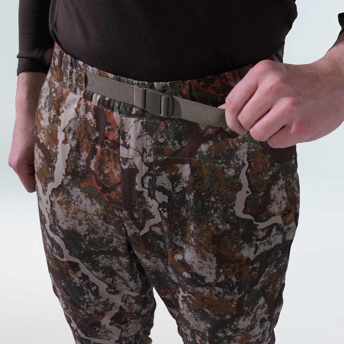 Brown, green, and grey camouflage pants with an integrated light grey webbing belt and matching buckle, being adjusted by a hand.