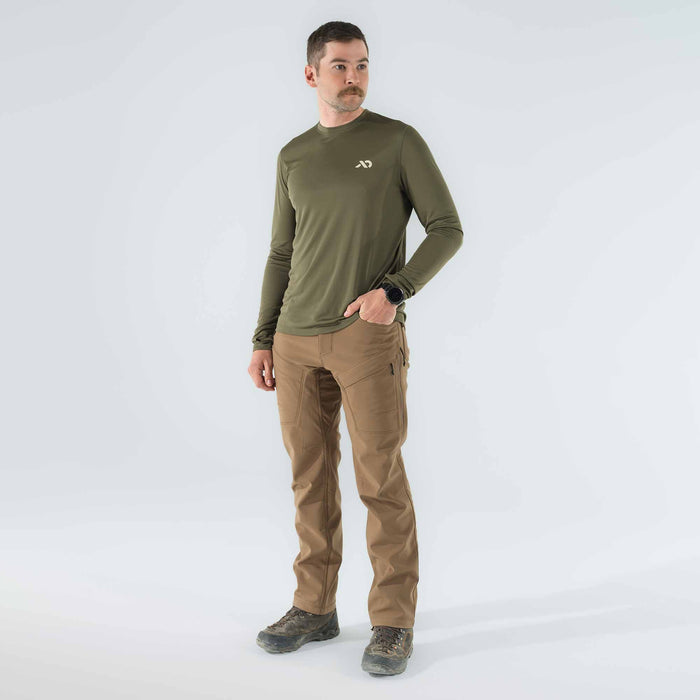 A man wears an olive green long-sleeve shirt with a white chest logo and tan tactical pants with zippered thigh pockets.