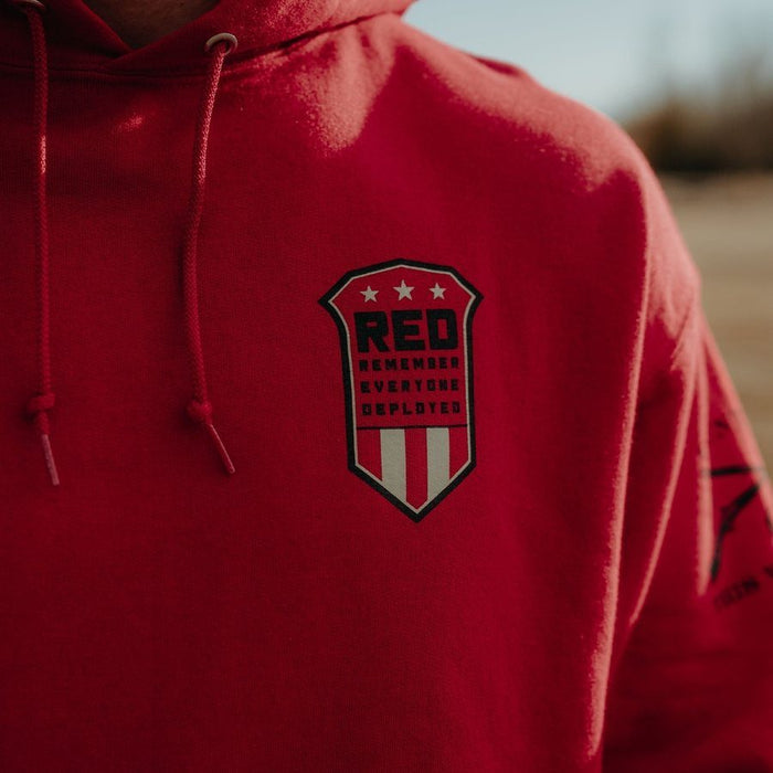 Red hoodie with a black and white emblem on the chest.