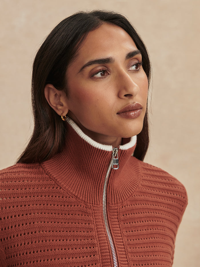 Maple|Close up of a model wearing Morwenna Half Zip Knit in Maple, highlighting the colar and zip.