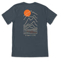 Dark heather gray t-shirt with a back graphic of an orange sun behind tan outline mountains, with the text "KEEP PUBLIC LANDS IN PUBLIC HANDS" and "FIRST LITE" below.