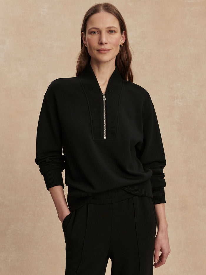 Black|Front view of a model wearing the Varley Sally Half Zip Sweat in Black, featuring a half-zip neckline and relaxed fit.