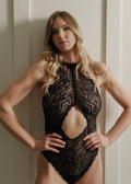 Soft lace halter bodysuit trimmed in velvet elastic and lined in 100% cotton. Cut out detail in center front gives a beautiful glimpse of skin.