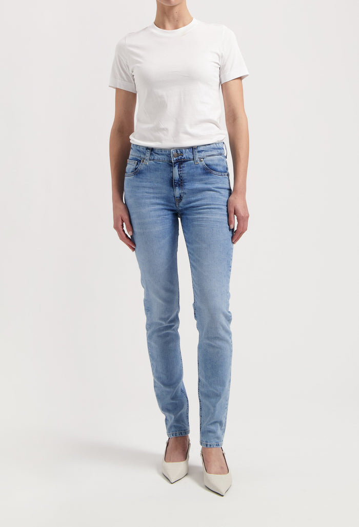 Casual chic outfit with light blue slim-fit jeans paired with a plain white T-shirt and pointy white heels.