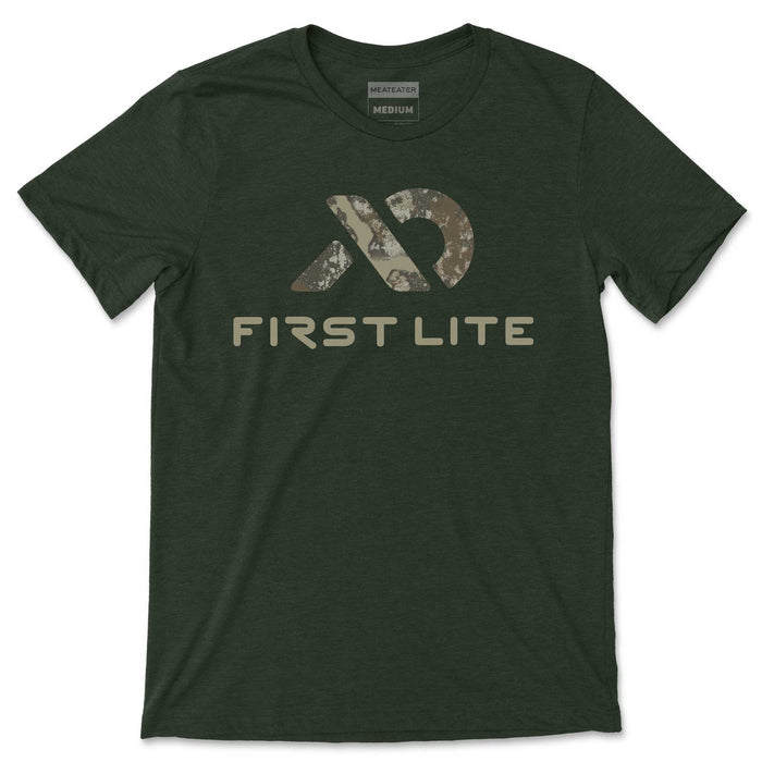 Dark green t-shirt with an abstract camouflage logo, "FIRST LITE" text, and a "MEATEATER MEDIUM" collar tag.