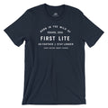 Navy t-shirt featuring white text graphic "Born in the Wild of Idaho, USA First Lite Go Farther | Stay Longer Since Before Smart Phones".