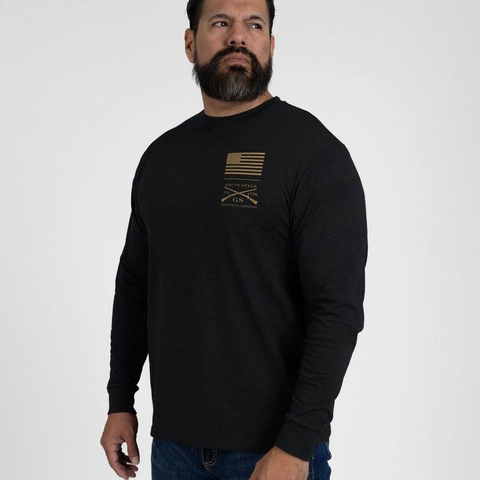 Man wearing a black long-sleeve shirt with a gold logo on a white background
