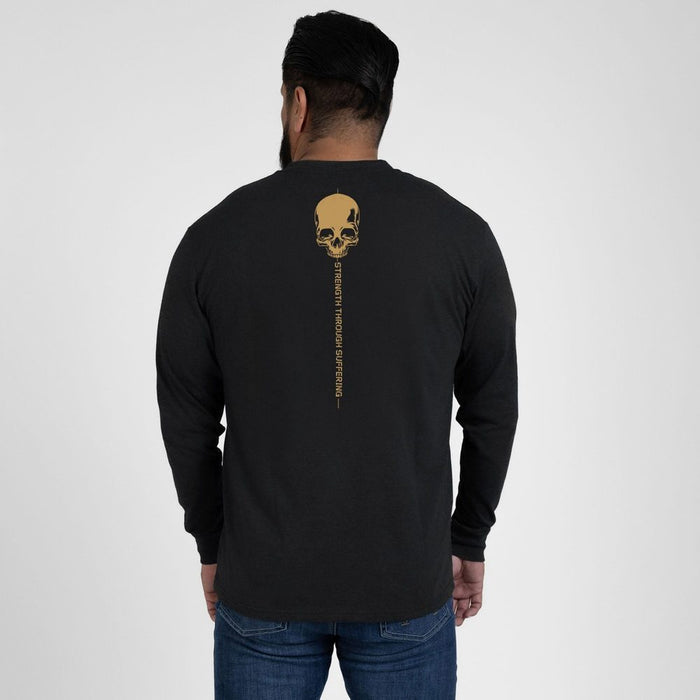Person wearing a black long-sleeve shirt with a gold skull design on the back, standing against a white background.