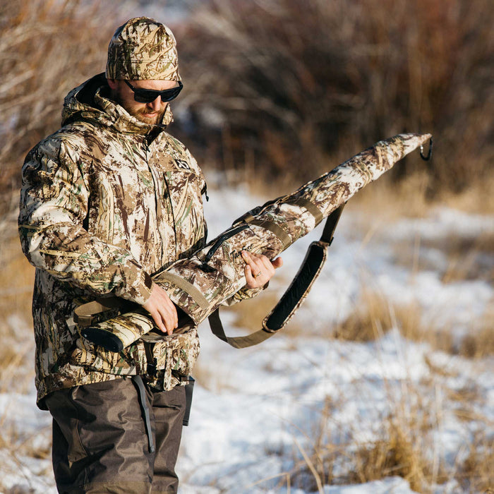 Tanglefree camouflage rifle case with zippered main compartment and padded shoulder strap, held by a man in camo.
