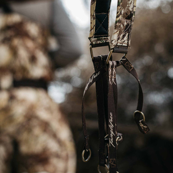 Camouflage duck strap with dark brown Tanglefree-branded loops and bronze metal rings.