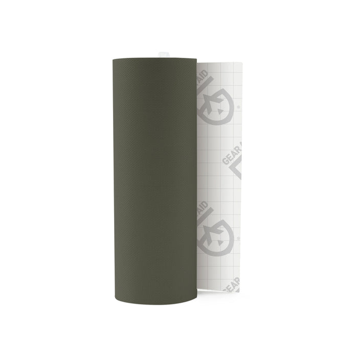 Olive green textured repair tape roll, partially unrolled to show white grid-lined backing paper with GEAR AID logo.