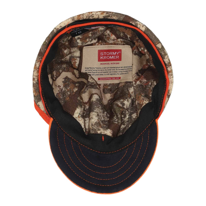 Camouflage baseball cap with orange trim, dark brim with orange stitching, and an interior Stormy Kromer brand label.
