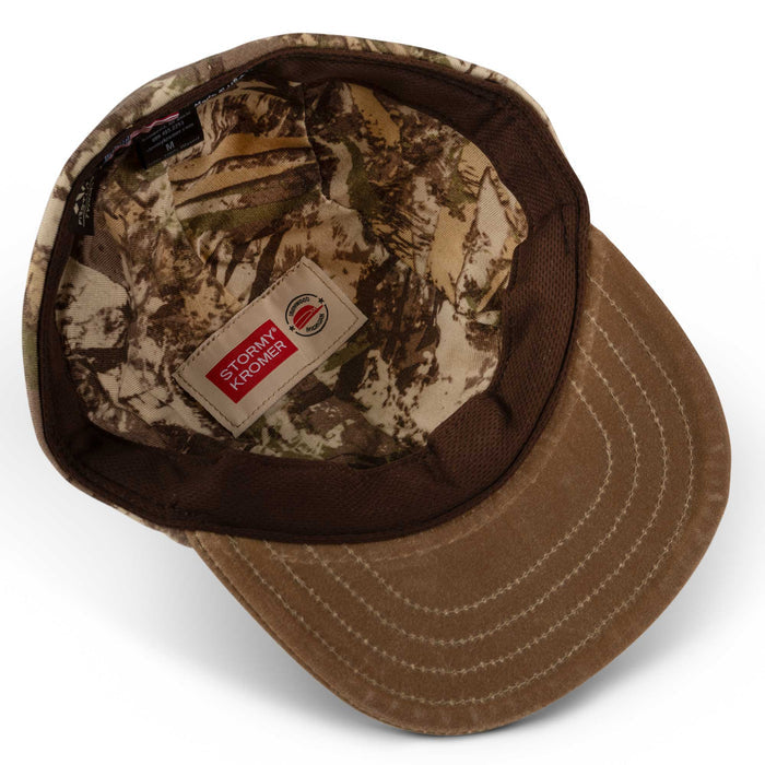 Camouflage cap interior showing a brown brim, mesh sweatband, and Stormy Kromer label.