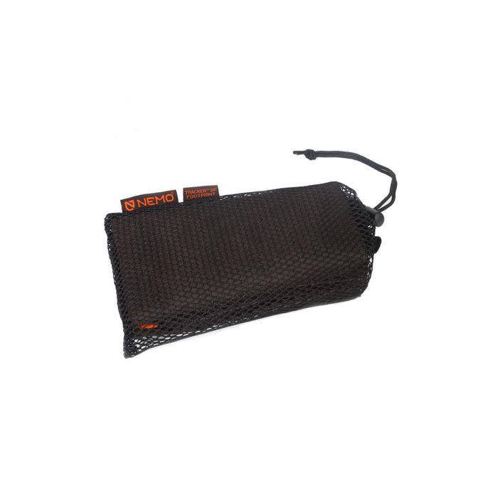 A black mesh drawstring sack holding a NEMO Tracker 2P Footprint, with orange NEMO and Tracker labels visible.