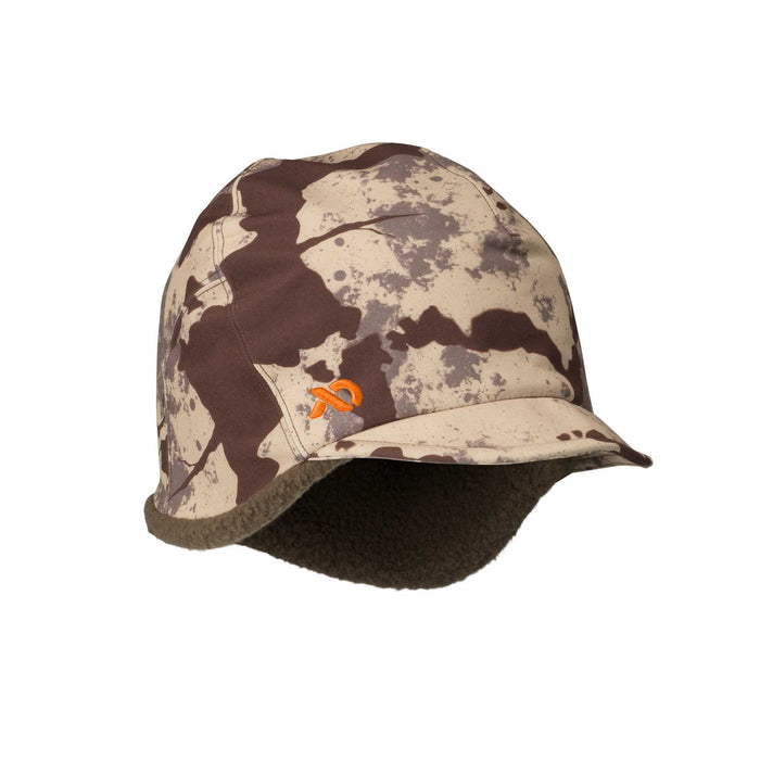 A brown, beige, and grey camouflage winter hat with a short brim, ear flaps, and an orange embroidered logo on the front.