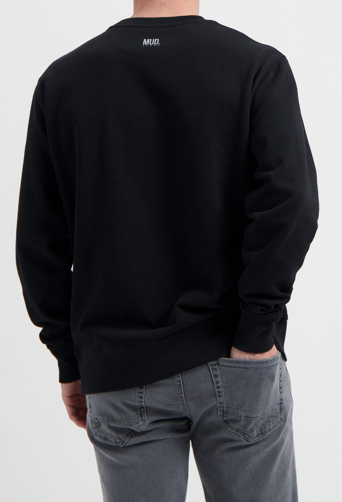 Sustainable MUD Jeans in gray worn with a black ethical sweatshirt, showcasing eco-friendly fashion choices.