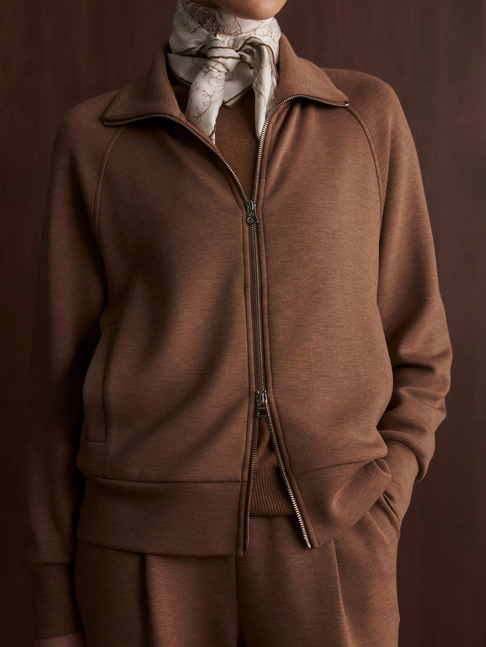 Golden Bronze Marl|Model standing facing forward with hands in pockets, wearing the Tyde Zip Through Sweat in golden bronze marl, featuring a two-way zip, knitted collar, vertical welt pockets, and crafted from Varley’s signature DoubleSoft® fabric.