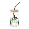 Can-shaped glass featuring the Wicked Defy Gravity theme, complete with lid and straw against a neutral background