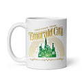 White ceramic coffee mug featuring a vibrant Emerald City graphic illustration from Wicked on the front