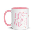 White ceramic coffee mug with pink rim, handle, and interior, featuring Wicked The Best Witch of All graphic on the front