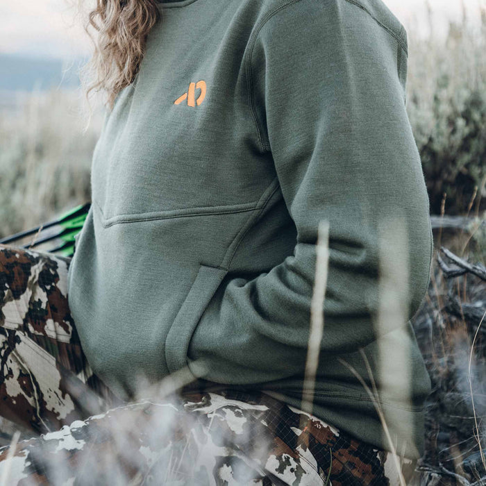 Olive green sweatshirt featuring an orange chest logo, a horizontal chest seam, and side pockets.