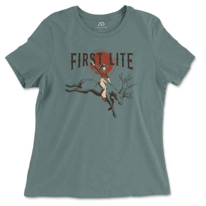 Muted teal t-shirt featuring "FIRST LITE" text above a graphic of a cowgirl riding a leaping elk against a red sun.