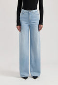 Light blue, high-waisted wide-leg jeans paired with a long-sleeve black top, showcasing a modern casual style.